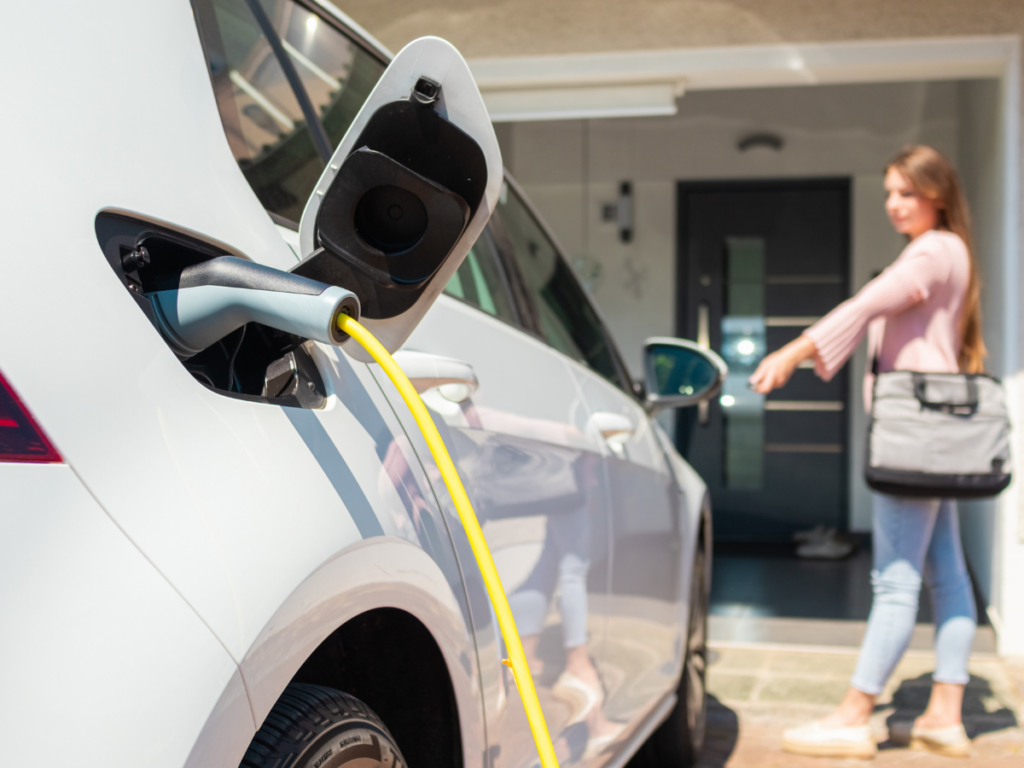 Homeowner charging vehicle in driveway 