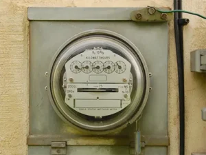 Analog electric meter box mounted on a residential property wall in Tampa.